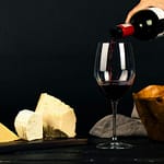 Enjoy a fine dining experience with red wine and gourmet cheese displayed elegantly.