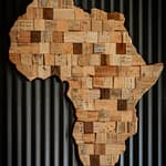 Artistic wooden map of Africa against dark corrugated background.