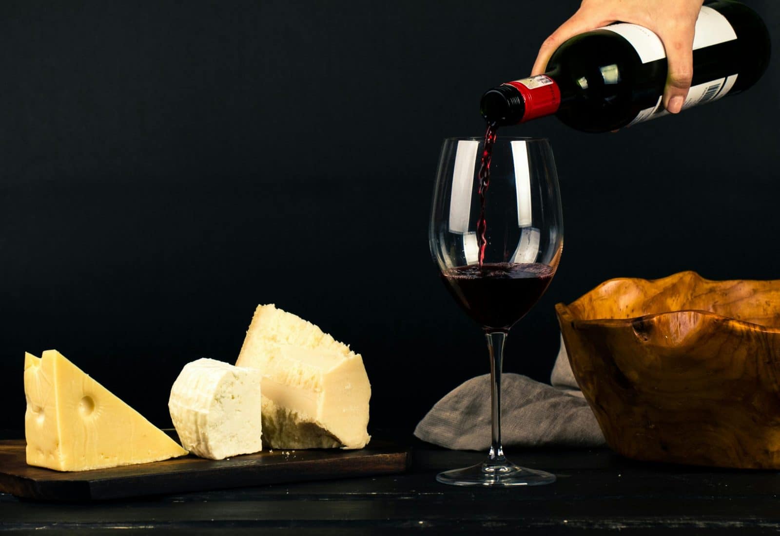 Enjoy a fine dining experience with red wine and gourmet cheese displayed elegantly.